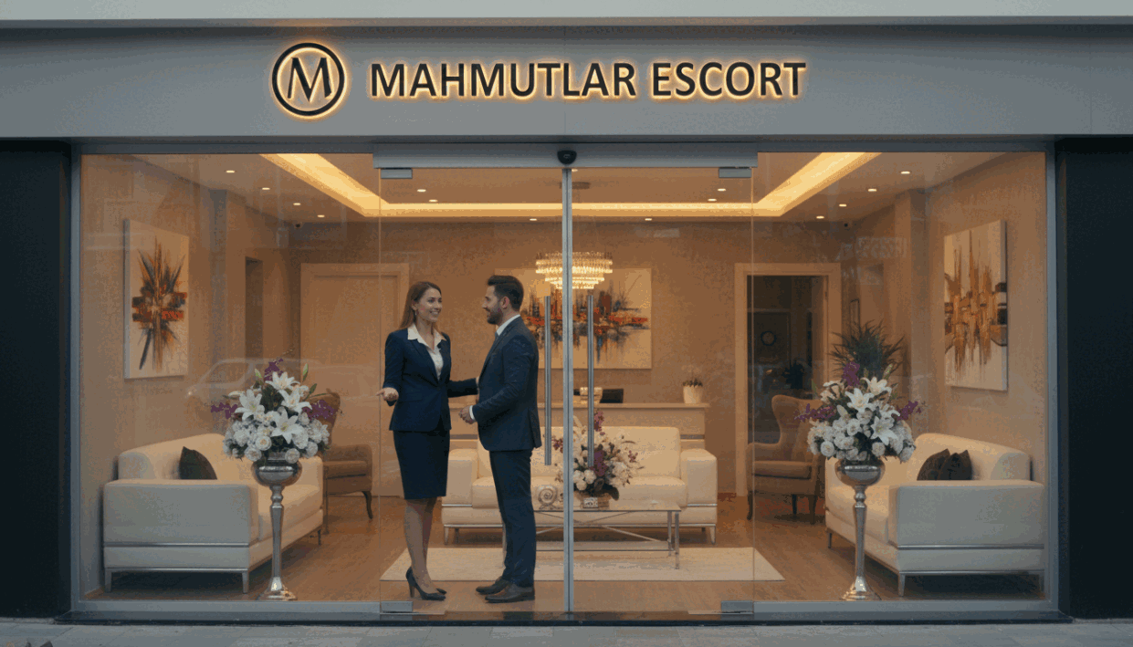 A vibrant street scene in Mahmutlar, showcasing a modern and professional escort agency's entrance, prominently featuring the brand name "Mahmutlar Escort" on a stylish sign. In the foreground, a welcoming and elegant reception area is visible through large glass doors, decorated with tasteful floral arrangements and soft ambient lighting. In the middle, a well-dressed receptionist in business attire is smiling, engaging with a client. The background features a chic and contemporary interior design with comfortable seating and contemporary artwork, creating an atmosphere of luxury and professionalism. The setting is illuminated with warm lighting, capturing a welcoming and secure environment, ideal for quality escort services. The angle is slightly elevated, providing a comprehensive view of the inviting atmosphere while ensuring all elements remain SFW. A vibrant street scene in Mahmutlar, showcasing a modern and professional escort agency's entrance, prominently featuring the brand name "Mahmutlar Escort" on a stylish sign. In the foreground, a welcoming and elegant reception area is visible through large glass doors, decorated with tasteful floral arrangements and soft ambient lighting. In the middle, a well-dressed receptionist in business attire is smiling, engaging with a client. The background features a chic and contemporary interior design with comfortable seating and contemporary artwork, creating an atmosphere of luxury and professionalism. The setting is illuminated with warm lighting, capturing a welcoming and secure environment, ideal for quality escort services. The angle is slightly elevated, providing a comprehensive view of the inviting atmosphere while ensuring all elements remain SFW.