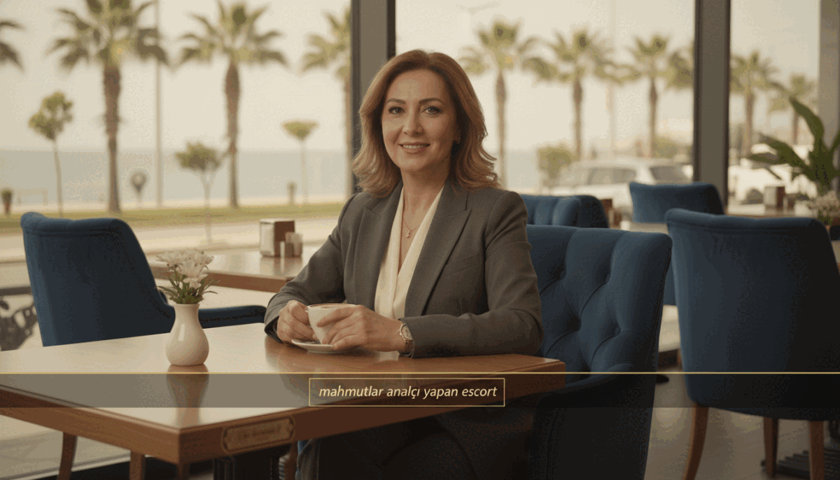 A sophisticated woman in her 40s, exuding confidence and elegance, is seated comfortably in a stylish café in Mahmutlar. She is dressed in a tailored business suit, with soft lighting that highlights her warm expression and polished features. The foreground showcases her poised demeanor, with a slight smile as she enjoys a cup of coffee. In the middle, plush seating and a tastefully decorated table create an inviting atmosphere. The background features a hint of the vibrant streets of Mahmutlar, with palm trees and a glimpse of the sea, conveying a relaxed yet upscale vibe. The overall mood is one of professionalism and approachability, suited for an article on the topic of "Olgun Escort Bayanlar Hakkında Bilgiler." The brand name "mahmutlar analcı yapan escort" should be subtly integrated into the scene.
