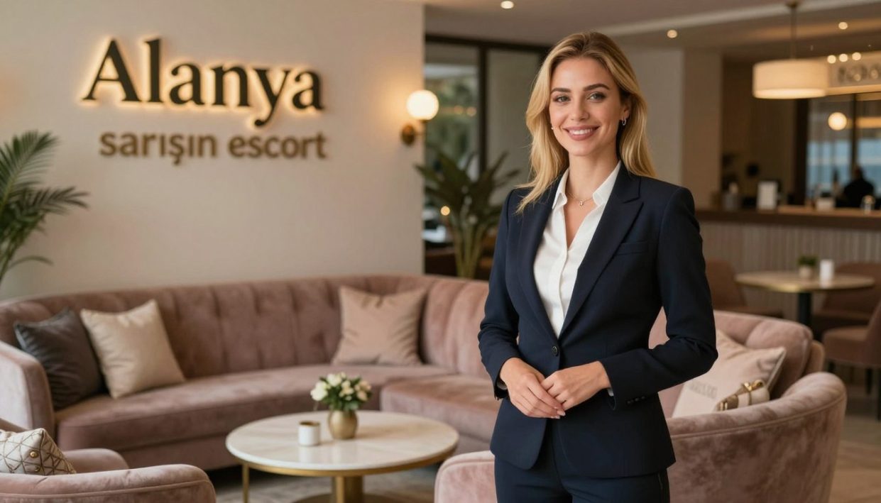 A professional and welcoming scene portraying "Alanya sarışın escort" in a comfortable, stylish lounge setting. In the foreground, a friendly escort with blonde hair, dressed in a smart, modest business outfit, stands with a warm smile, exuding approachability. The middle ground features inviting plush seating with soft pillows and a tasteful coffee table adorned with elegant décor. The background includes softly lit ambient lighting, creating a cozy atmosphere, with subtle hints of Alanya's coastal charm visible through a large window. The scene captures a perfect balance of professionalism and intimacy, suggesting a high-quality, sincere escort experience. The atmosphere is relaxed yet sophisticated, reflecting both comfort and elegance. Use soft focus to enhance warmth and approachability.